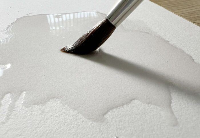 doser l'eau en aquarelle avec un pinceau sur papier humide